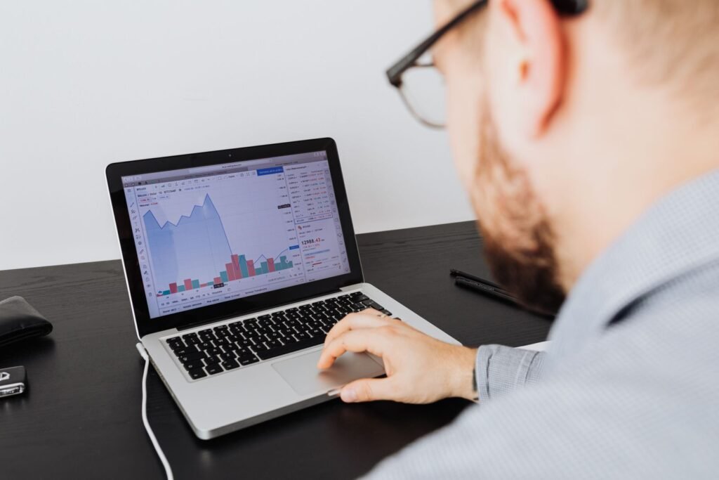 Business professional analyzing marketing data and financial graphs on laptop